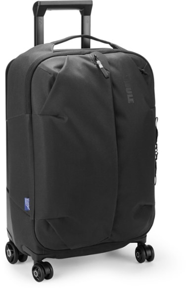 Front view of spinner suitcase showing oversized wheels and recycled canvas exterior.
