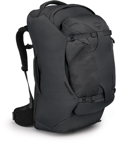A man wearing the Osprey Farpoint 70 travel backpack, shown from a rear angle, highlighting its adjustable harness and substantial capacity for a long journey.