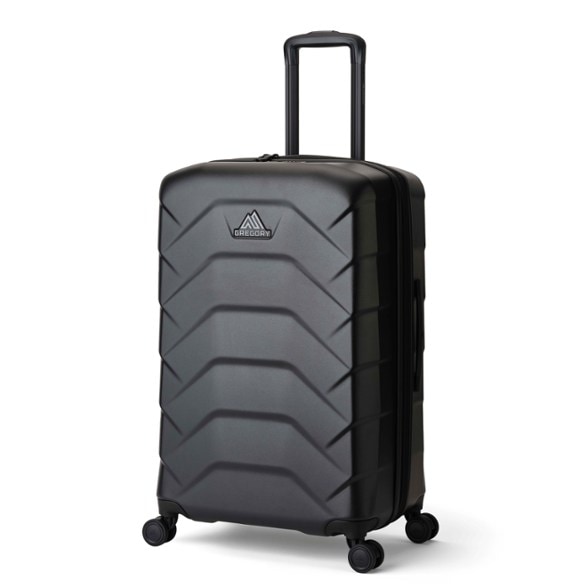 Gregory Cache 28-inch spinner suitcase rolling through airport with telescopic handle extended