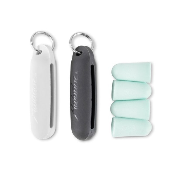 Close-up of Matador SnoozeMate™ sleep earplugs with travel case on a plane tray table
