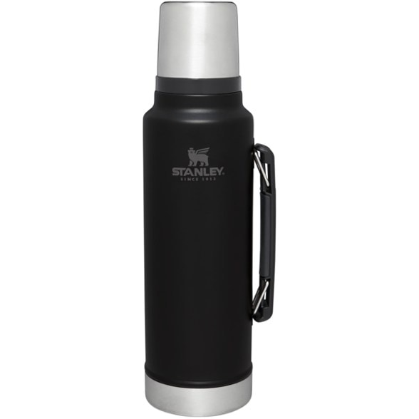 Stanley LegendVac insulated water bottle shown on rocky outdoor trail with handle extended