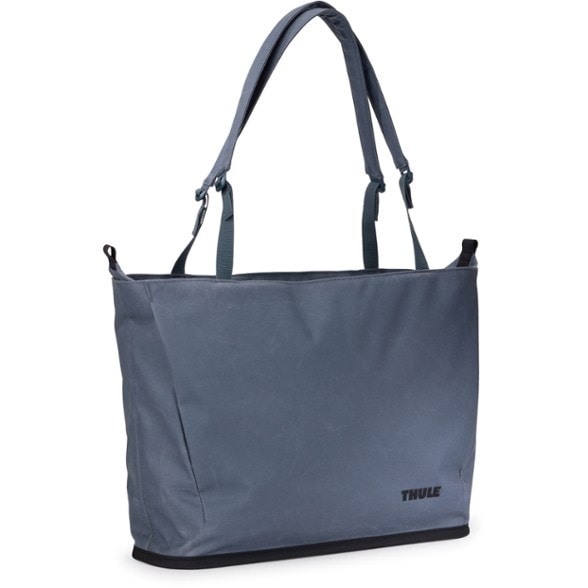 Thule Aion tote bag in a stylish office setting, showcasing its large capacity and detachable inner sling bag.