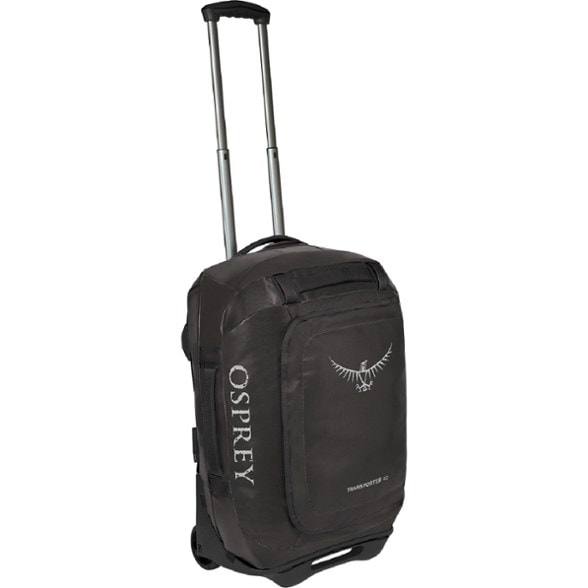 Angled front view of the wheeled duffel packed for a weekend trip with rugged terrain in the background