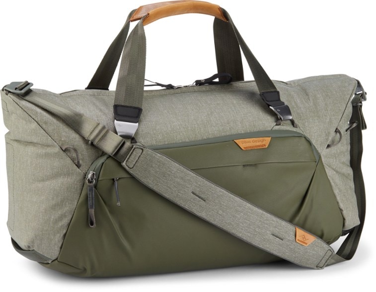 Side view of rugged travel duffel showing multiple exterior pockets