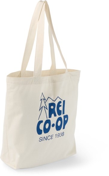 Eco-friendly canvas tote bag with art, filled with groceries and hanging from a hook