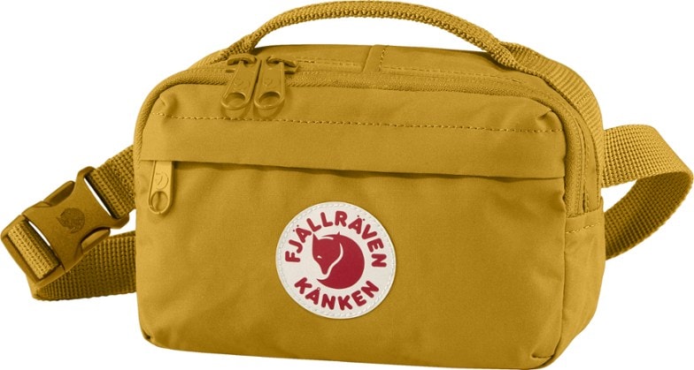 Fjallraven Kanken hip pack in a vibrant color, worn by a person walking outdoors.