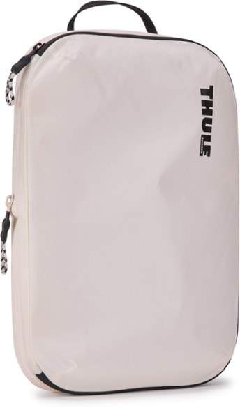 Thule compression packing cube open showing packed clothes for organized travel.