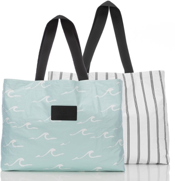 Reversible tote bag for women, featuring a waterproof design and interior zip pocket, perfect for travel and beach trips.