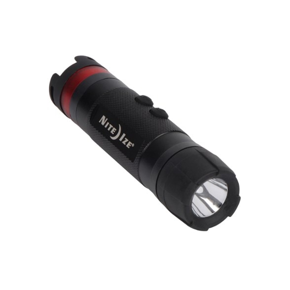 NiteCore Aurora Mini LED flashlight in flashlight mode, held by hand, shining a bright beam forward in a dark outdoor setting.