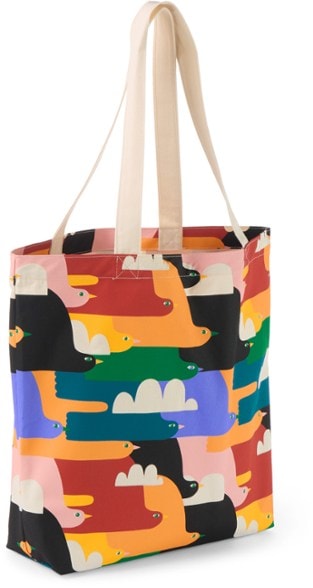 Pride eco-conscious canvas tote showcasing vibrant artwork while being held at a grocery store.