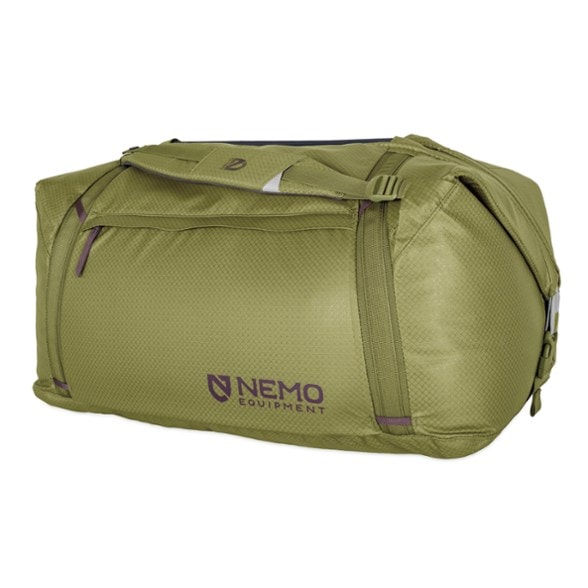 A person carrying the Expedition Pro 100L convertible duffel tote bag in duffel mode, demonstrating its spacious interior for camping gear, against a backdrop of a mountain trail.